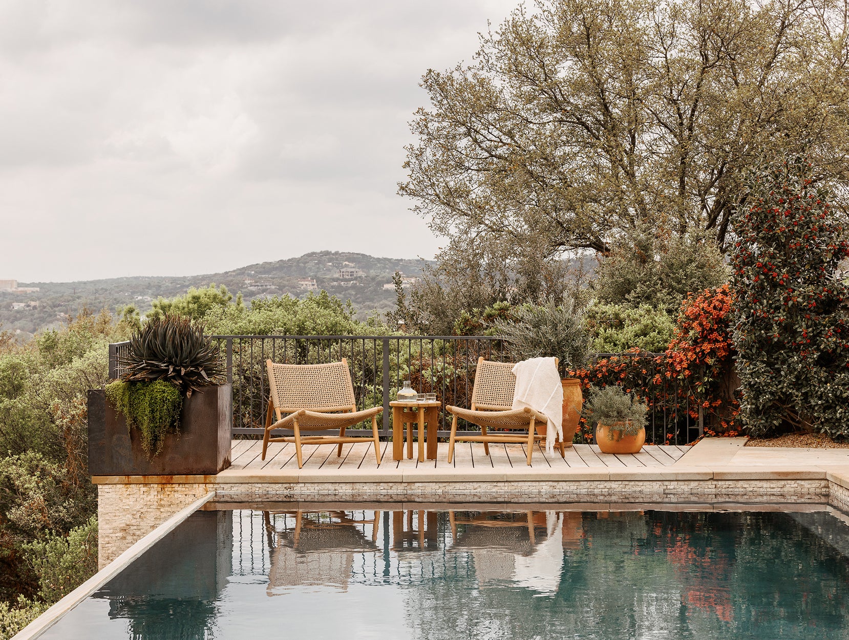 Outdoor nature space with pool and Bali lounge chairs.