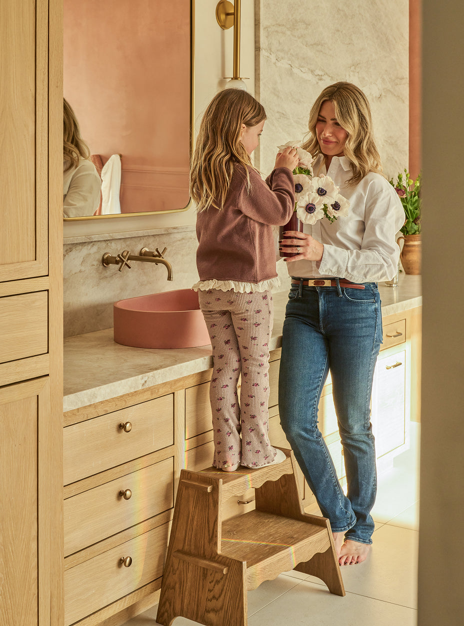 Christina Barraco with a child on a margot step stool in a bathroom.
