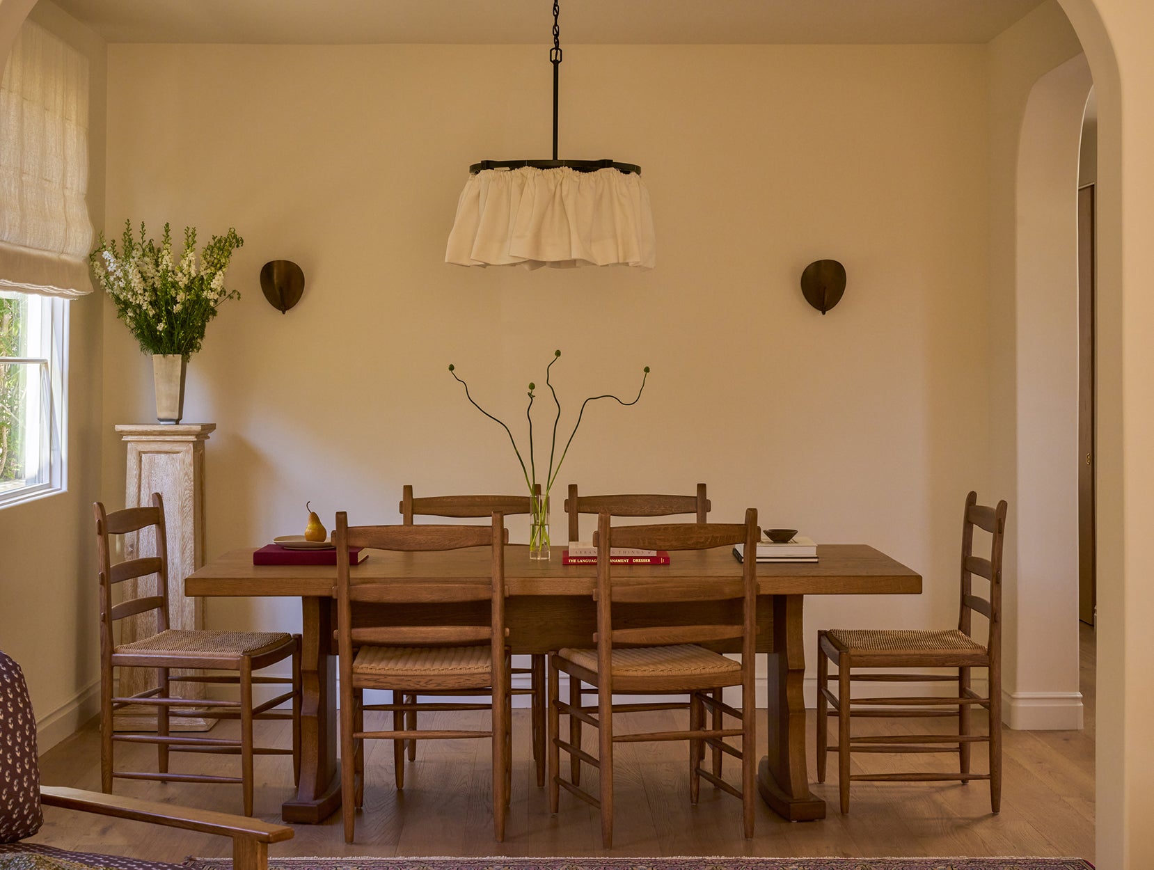 Dining room with Etta table and Tiga chairs, neutral walls, and decorative elements.
