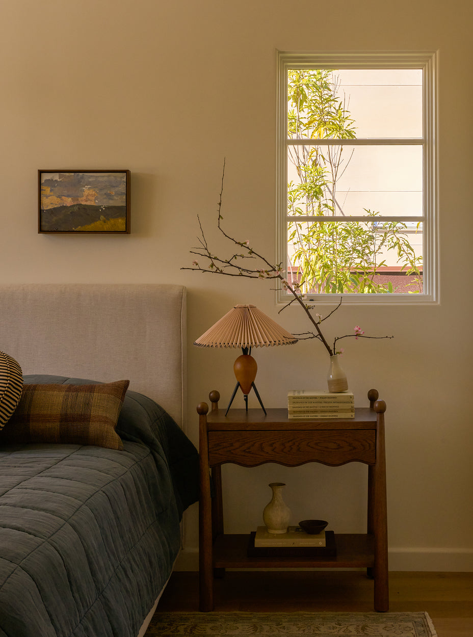 Guest room with the twist nightstand, lamp, and decorative items.