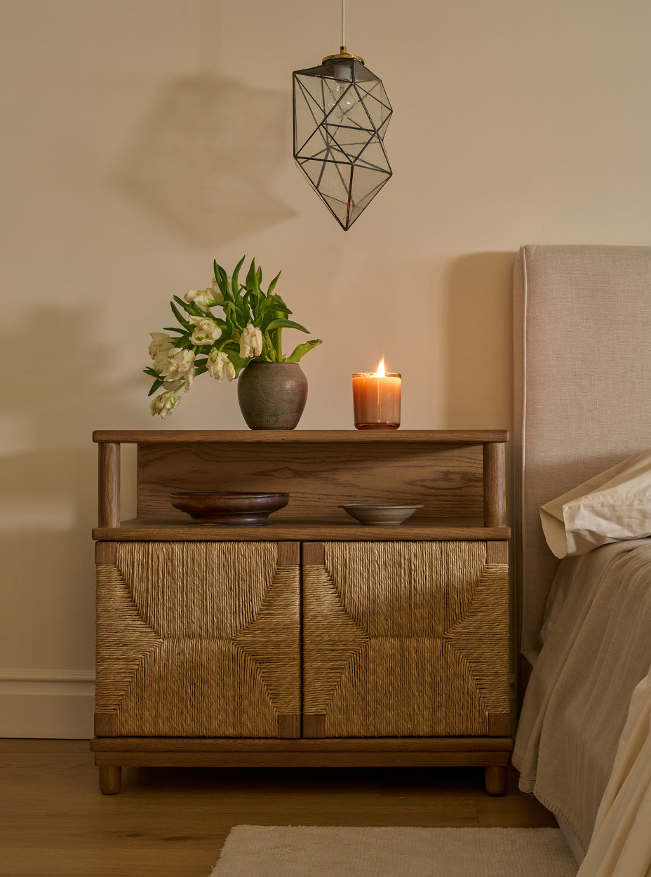 The suma nightstand with decorative items in a bedroom setting.