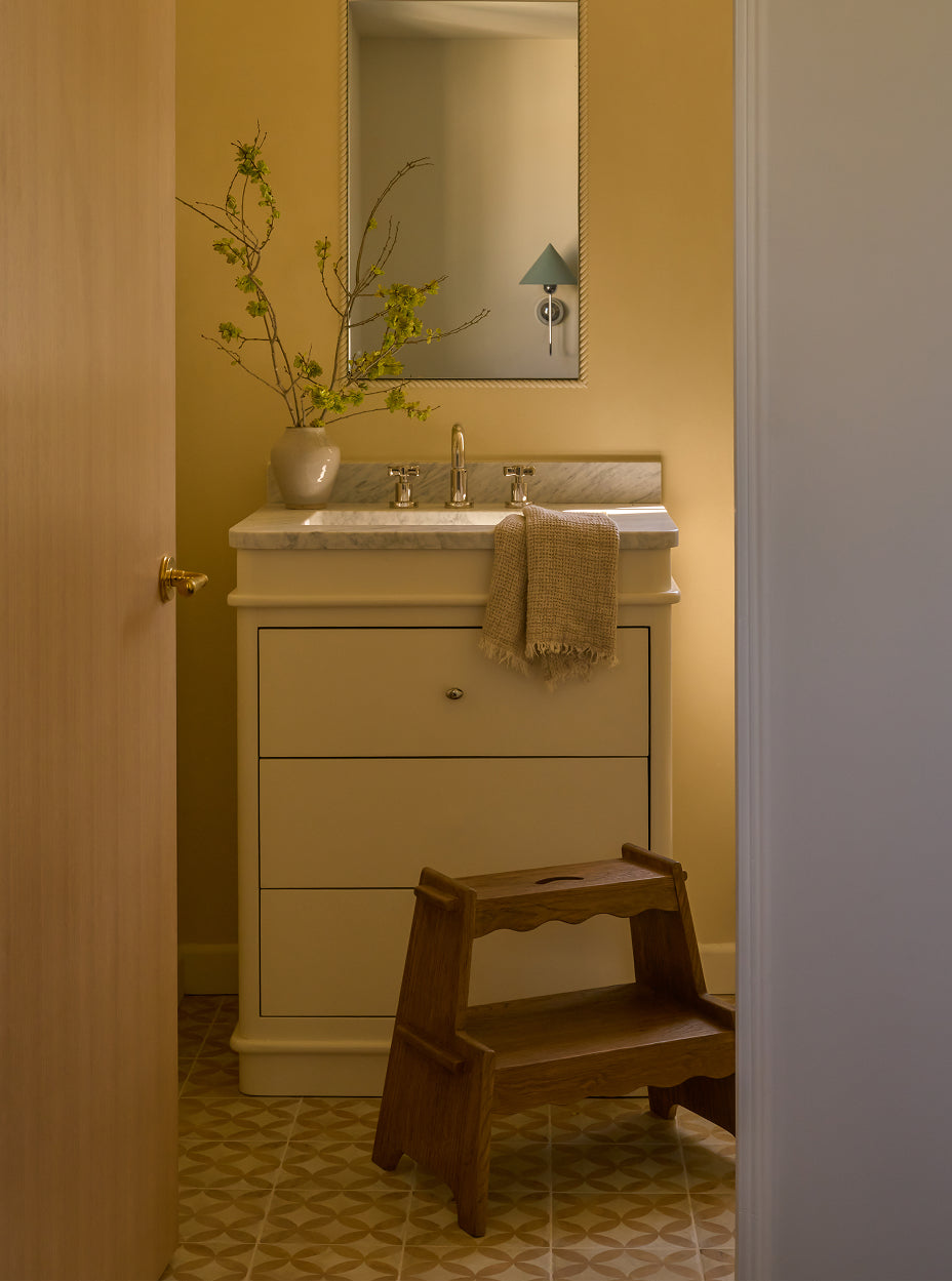 Bathroom with sink, the margot step stool, and decorative elements.