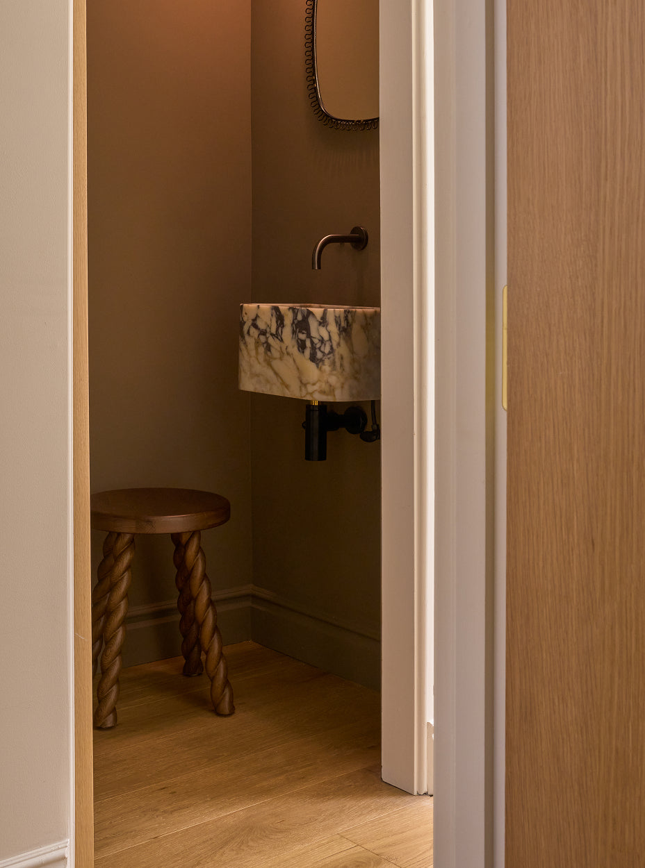 Bathroom with a sink and the twist side table, viewed from a doorway.