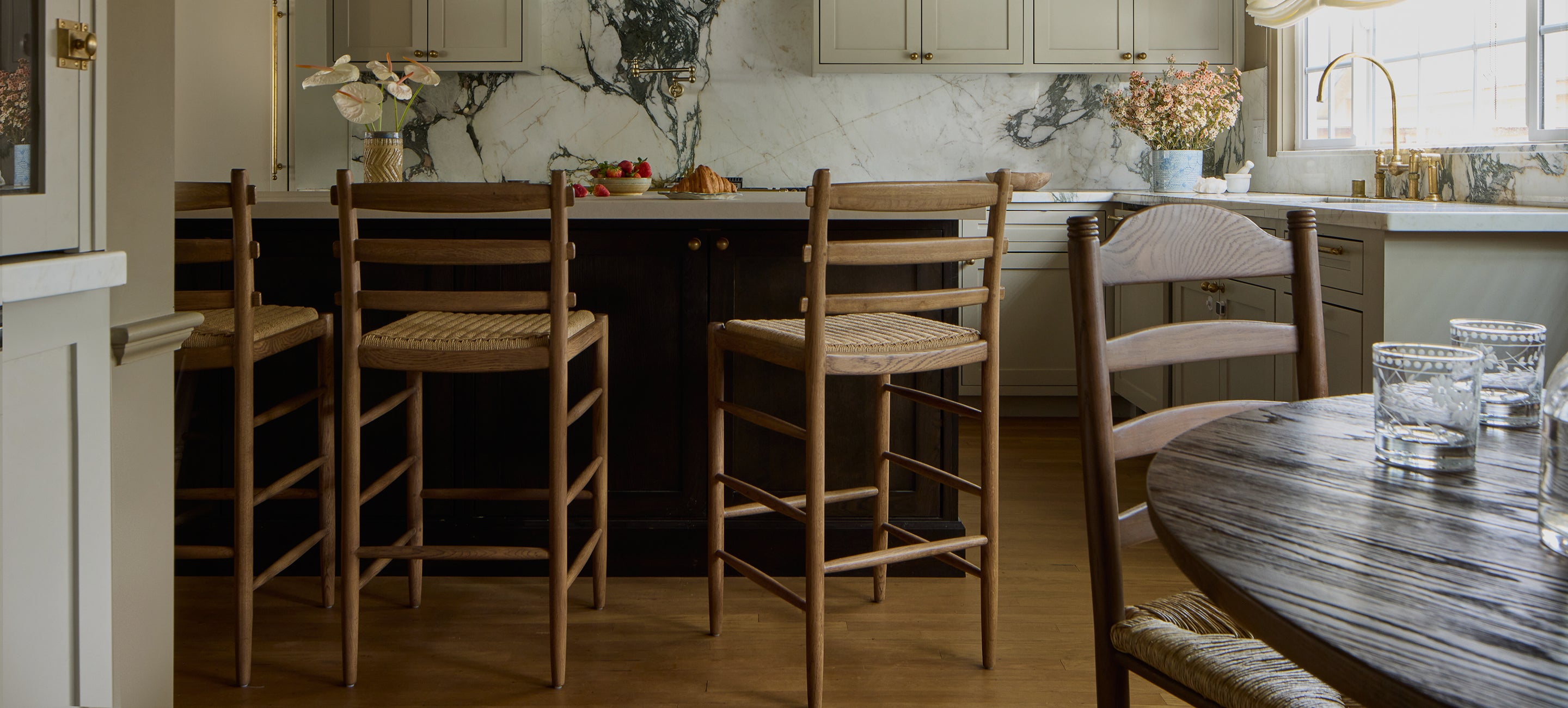 Kitchen with tiga counter stool around a dining table, cabinets, and a countertop.