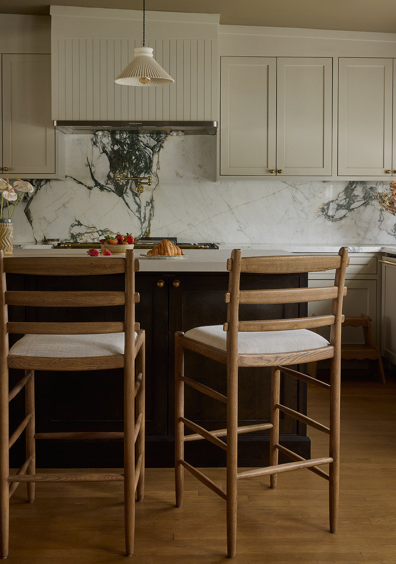 Kitchen with marble backsplash, tiga counter stools, and modern decor.