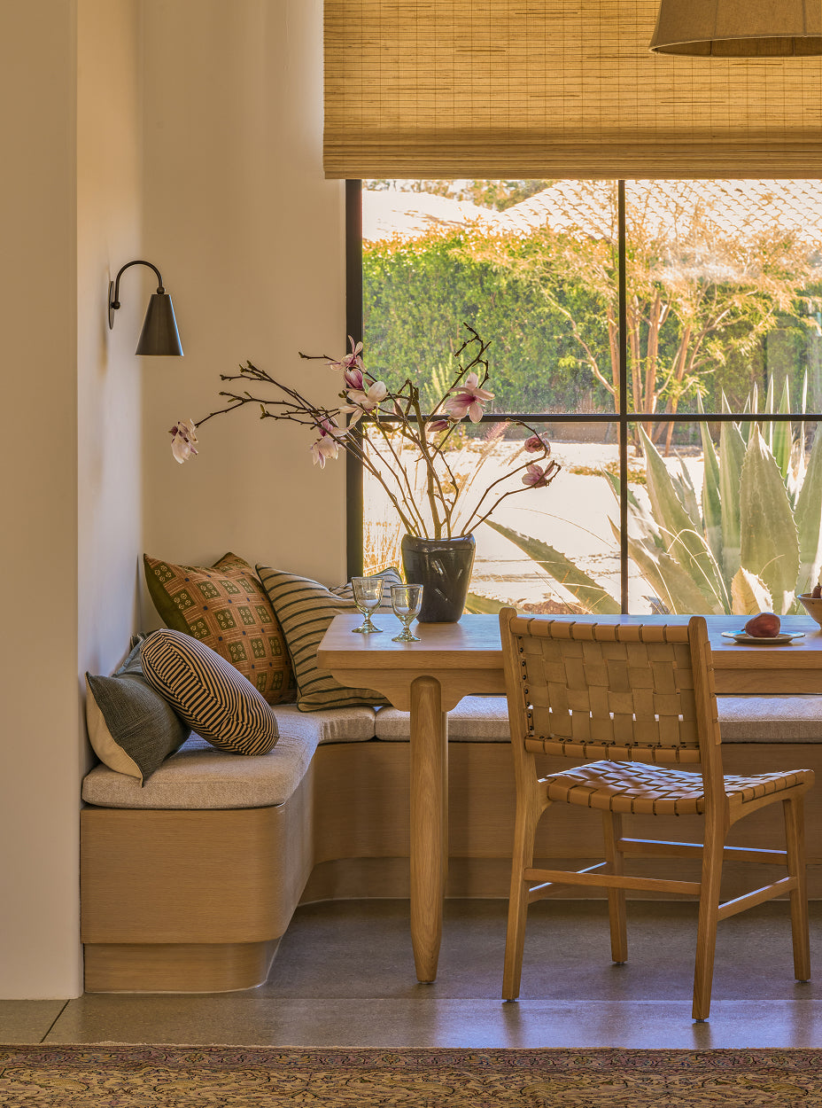 Dining area with a the anders dining table, the bali dining chairs, and a window view of greenery.