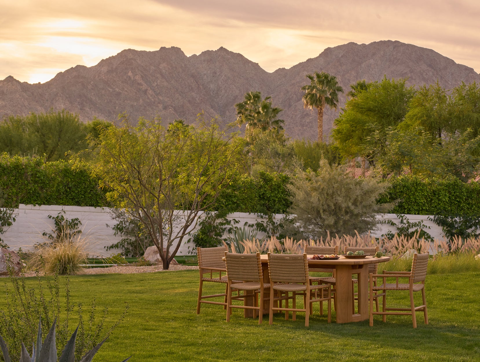 Outdoor dining setup with Ema chairs and Hollis table a scenic view of mountains.