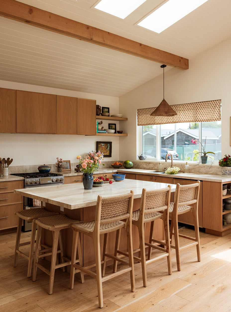 Modern kitchen with wooden island and bali counter stools, large window, and natural light.