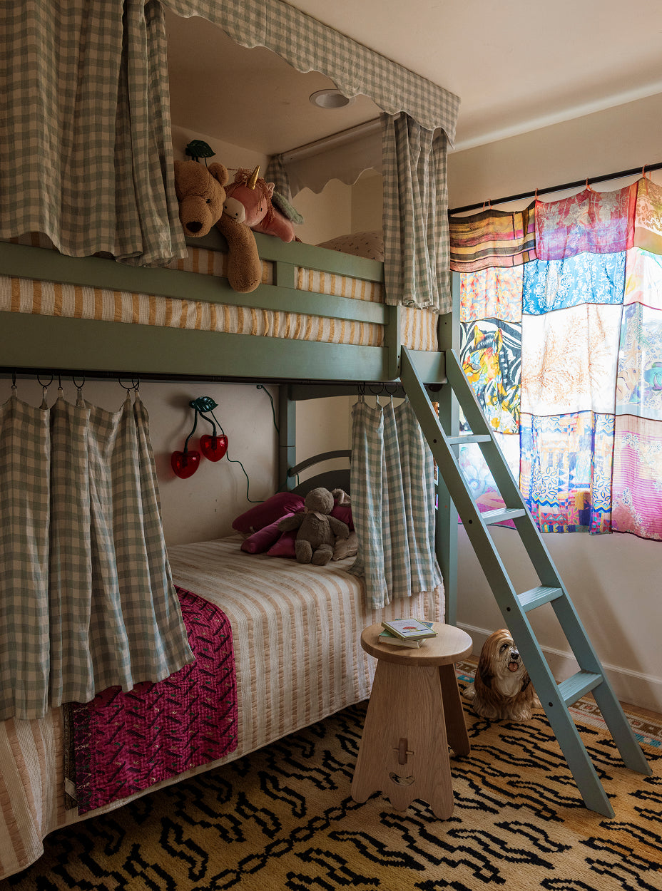 Children's bedroom with a green bunk bed, senja side table, colorful curtains, and toys.